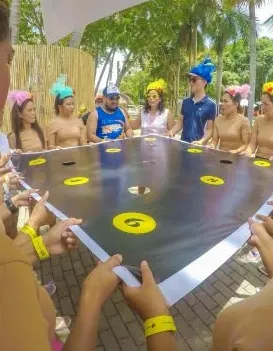 Team members holding the edges of a board together in a group challenge