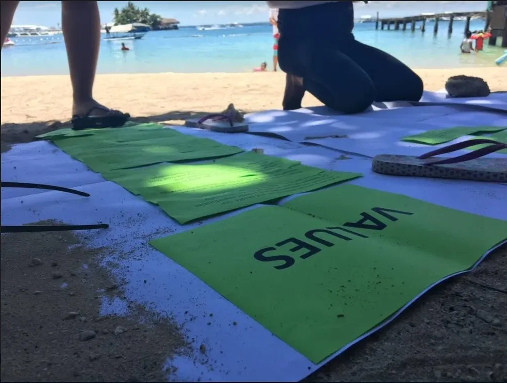 Values cards laid out on the sand during a beachside workshop